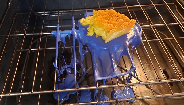 Hands holding a safe fiber container near an oven to demonstrate kitchen safety.