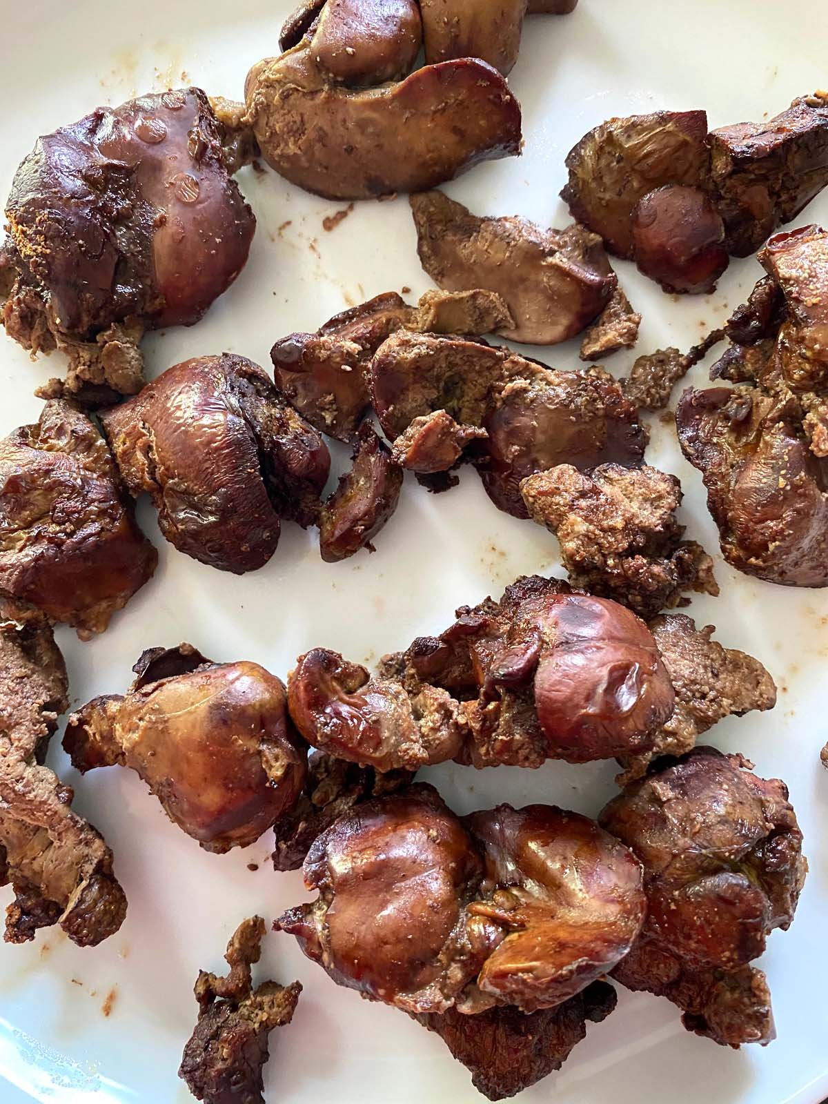Cooked chicken livers served on a plate with a digital thermometer nearby.