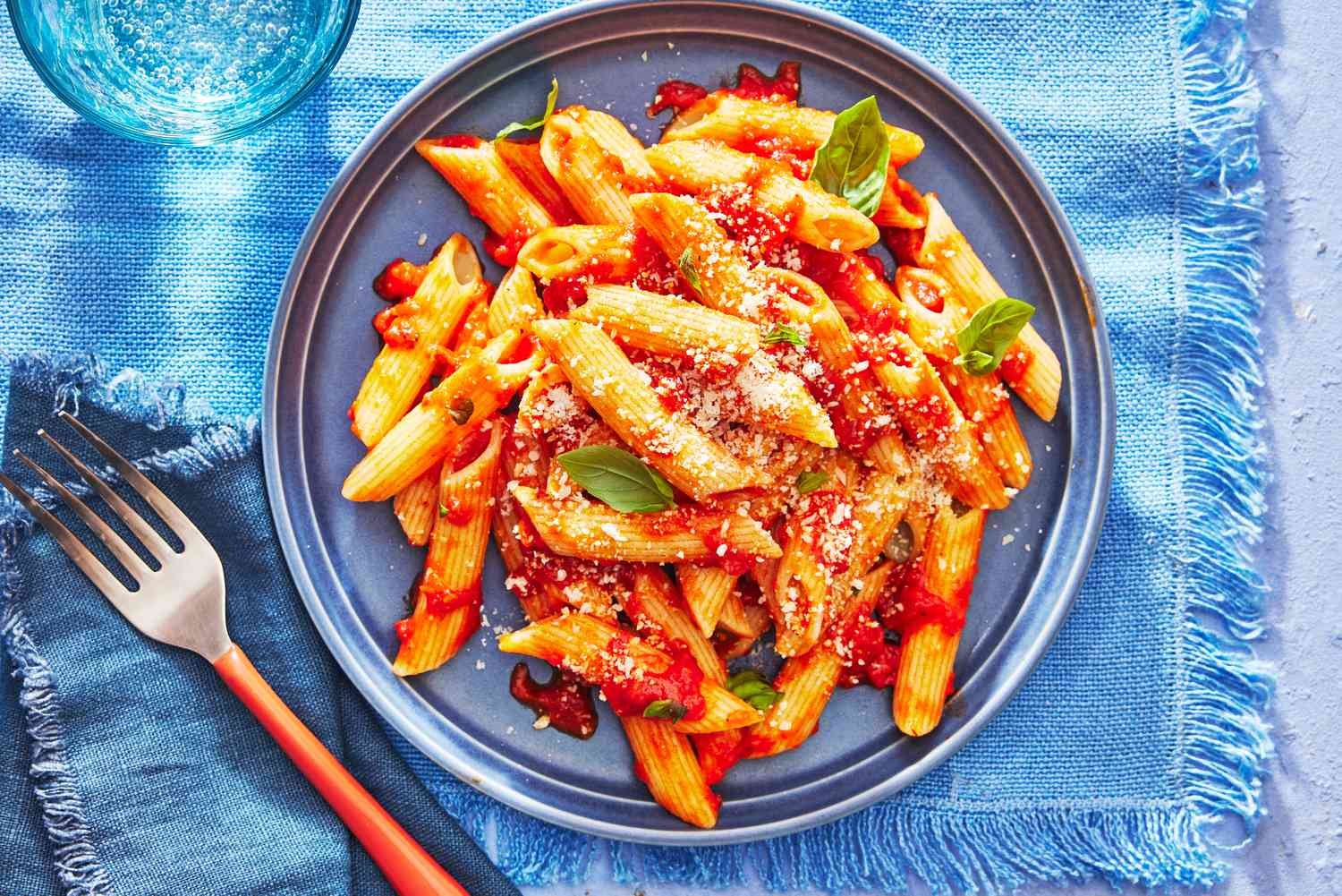 A bowl of perfectly cooked pasta sits in a bright, modern kitchen.