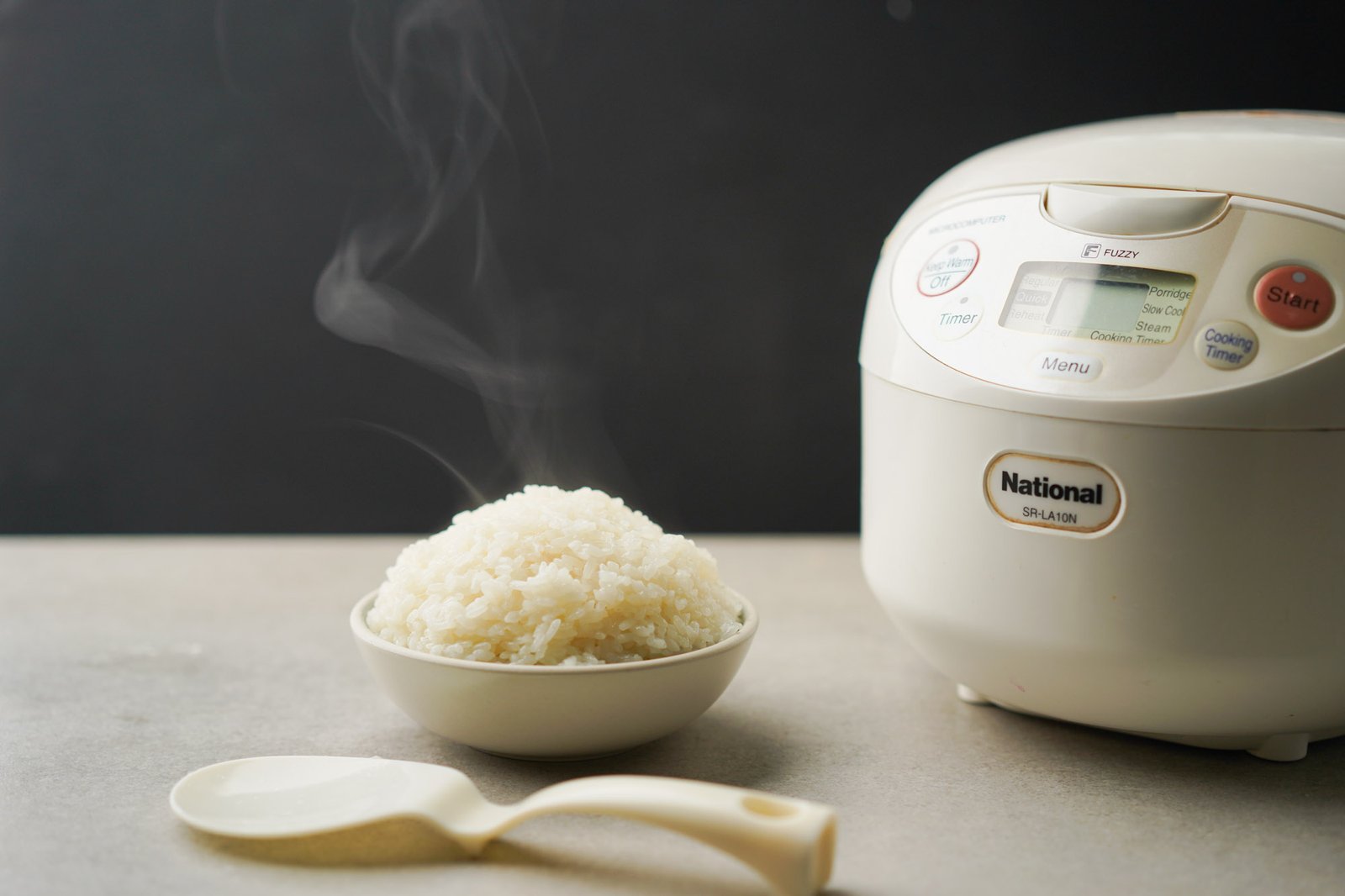 Plump soaked glutinous rice grains submerged in a glass bowl of clear water.