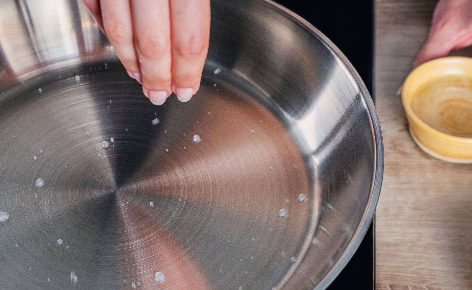 A stainless steel fork rests beside a glass of clear tap water.