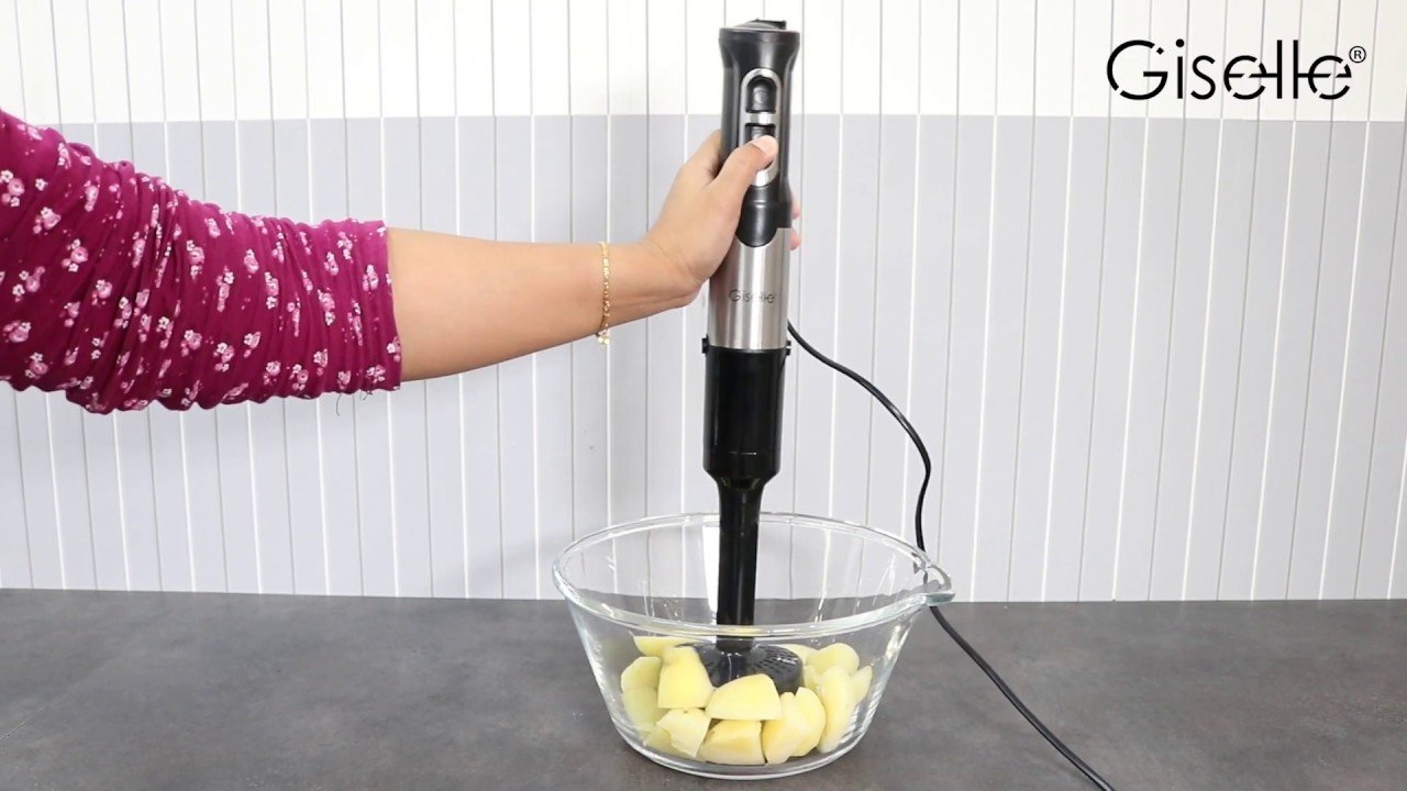 An immersion blender creates a smooth potato leek soup in a kitchen pot.
