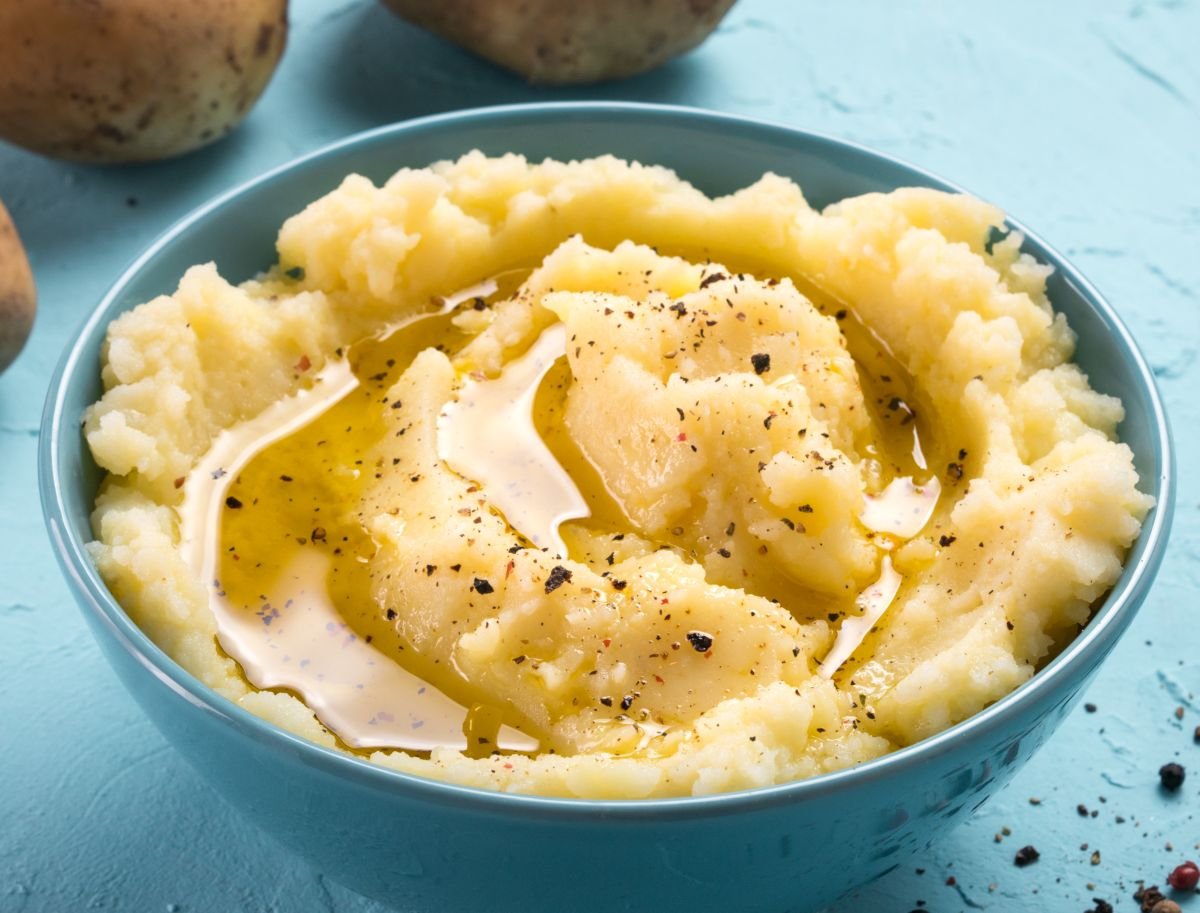 Various kitchen tools for mashing potatoes are arranged on a clean kitchen counter.